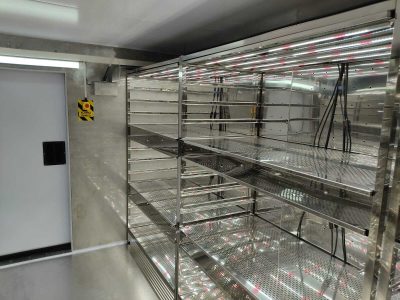 Interior of a visitable climatic chamber with Led lighting installation on the top of each shelf.